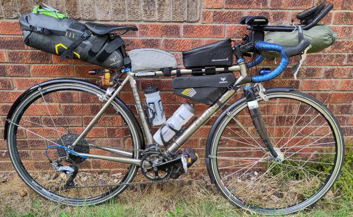 Fully laden road bike in front of brick wall