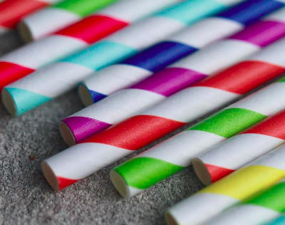 Striped paper straws of various colours on a flat surface