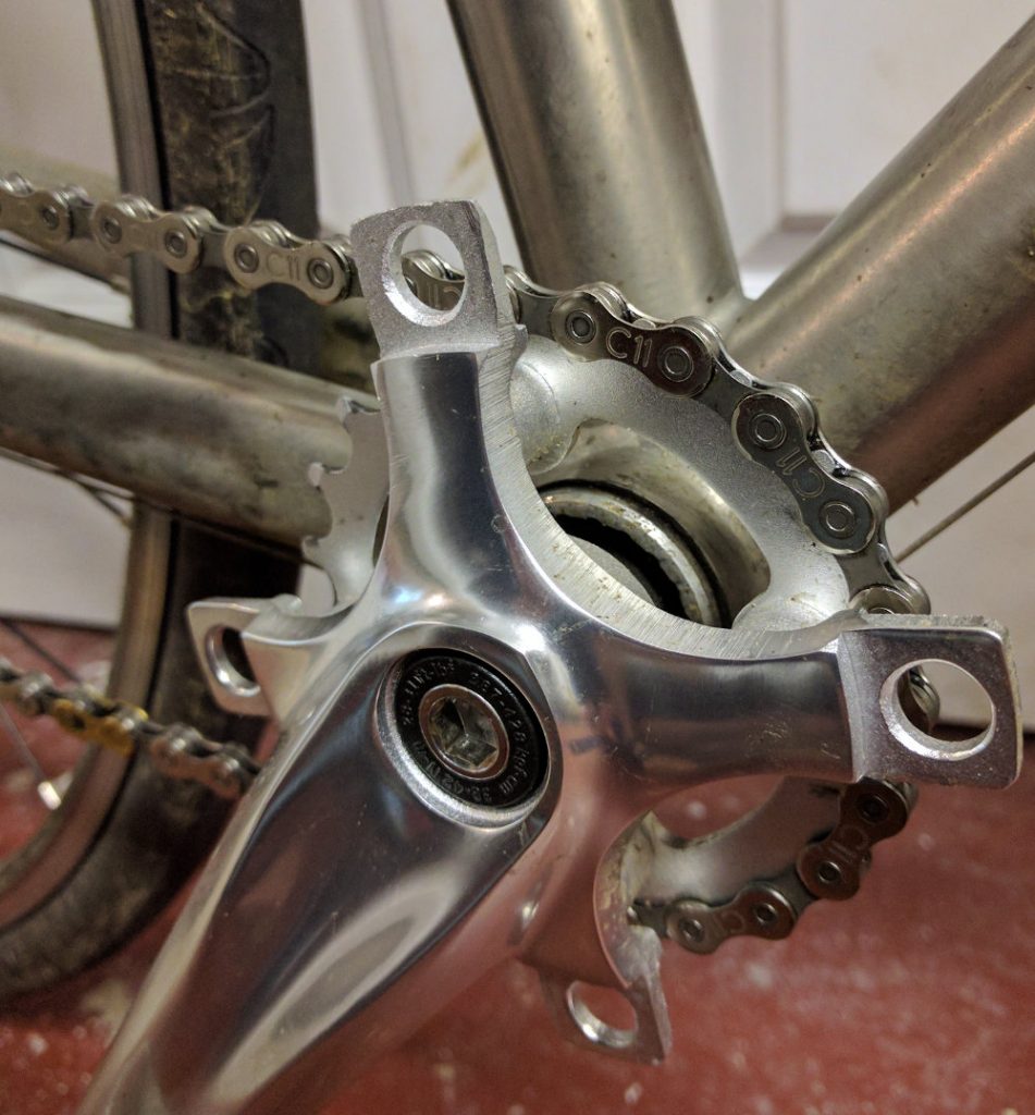 Small 22-tooth chainring mounted on titanium frame, missing larger rings